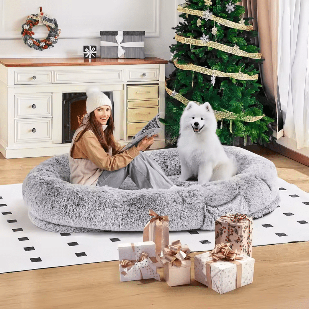 Human Dog Bed – Cozy, Ultra - Comfortable BedWoman with a dog in a fluffy pet bed surrounded by Christmas decorationsJoypup