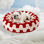 CozyPaw Donut Dog Bed – Modern Design, Soft & Warm, Washable Dog lying on a red and white patterned pet bed in a cozy room.