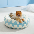 CozyPaw Donut Dog Bed – Modern Design, Soft & Warm, Washable Small dog sitting on a blue and white patterned pet bed.