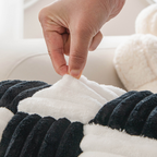 Fluffy Fuzzy Calming Dog Bed Sofa Protector Pet Mat Close-up of a hand touching a textured black and white blanket