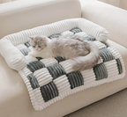 Fluffy Fuzzy Calming Dog Bed Sofa Protector Pet Mat Cat lying on a checkered pet bed with white and gray colors on a beige sofa.