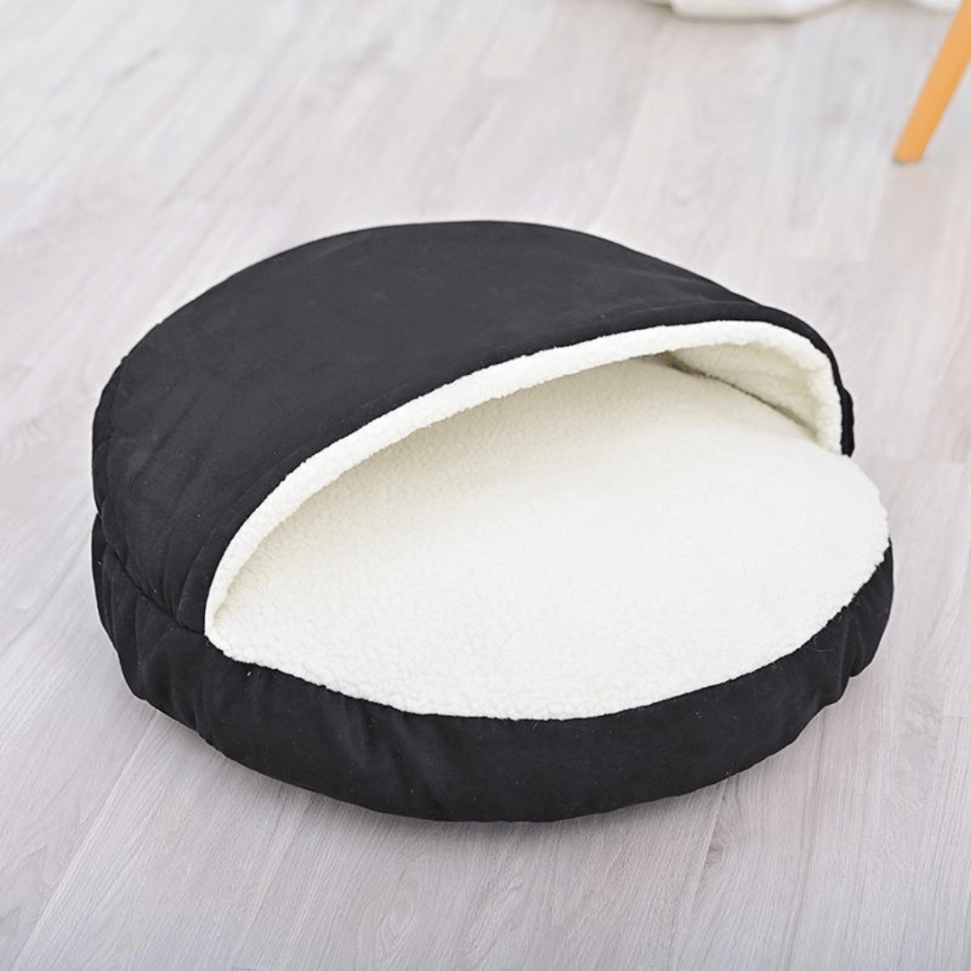 Calming Ultimate Anti-Anxiety Dog Bed – Cozy Hooded BedBlack pet bed with white interior on a light wooden floorJoypup