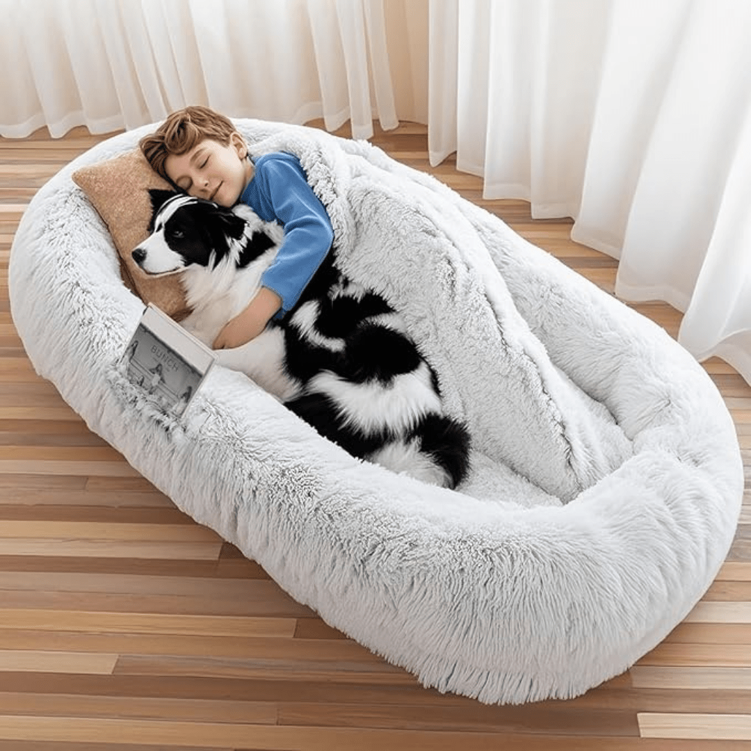 Human Dog Bed – Cozy, Ultra - Comfortable BedChild and dog lying on a fluffy pet bed in a room with curtains.Joypup