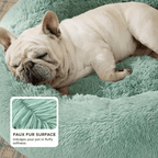 Dog sleeping on a plush green pet bed with a close-up of the faux fur surface.