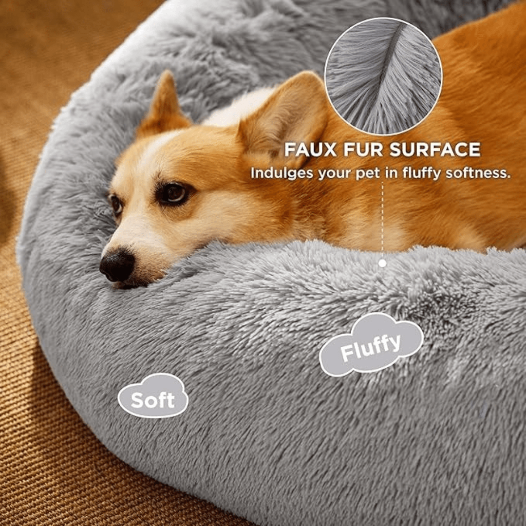 Soft Donut Cuddler Pet Bed - Ultimate Anti-AnxietyDog lying on a gray faux fur pet bed with text highlighting features.Joypup